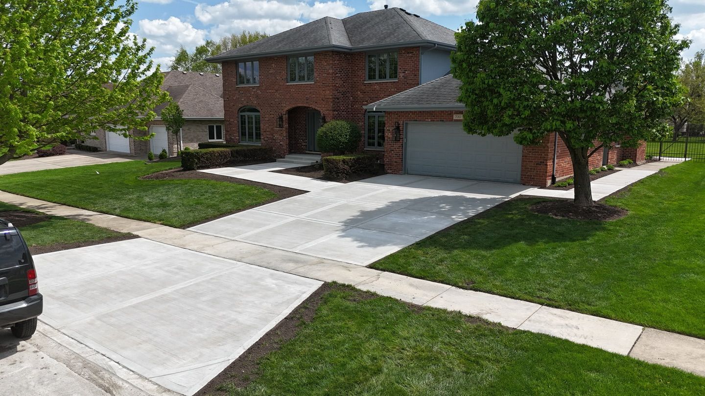 New concrete driveway and front walk at a brick home, seen from above