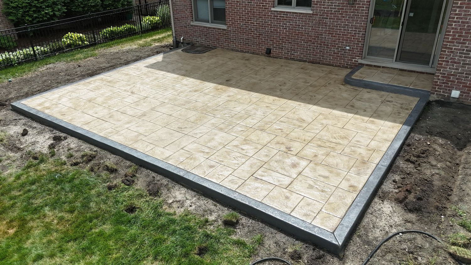 Stamped tan patio with a charcoal border